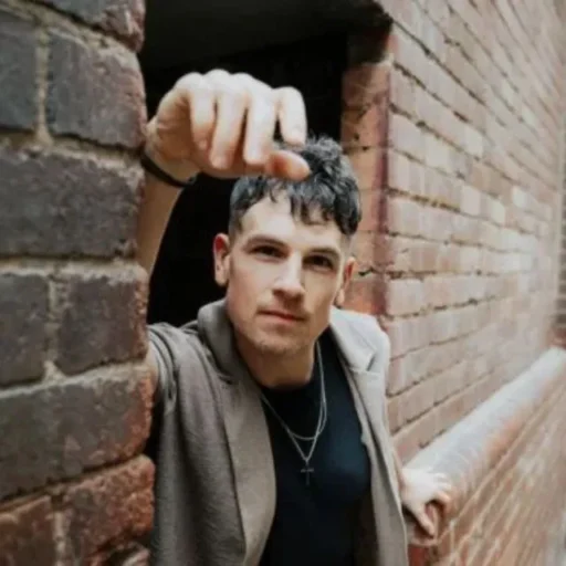 Michael Paynter - man leaning on a brick wall to promote his performance at Burnie Arts Centre on Saturday 11 July 2026 as part of Festival of Voices